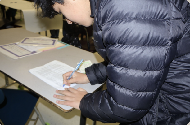 Student signing the breakfast petition 