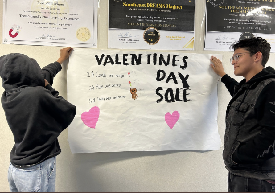 Leadership members Anderson & Kayli putting up the Valentine's Day Grams poster
