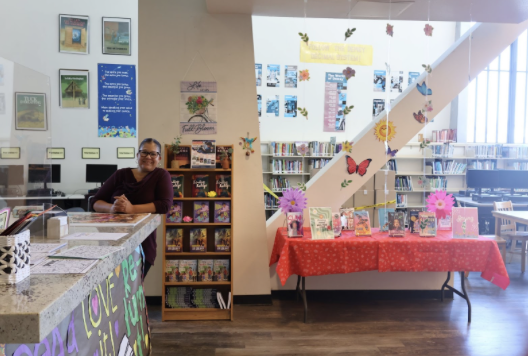 Librarian McCord standing in front of her spring display of books.
