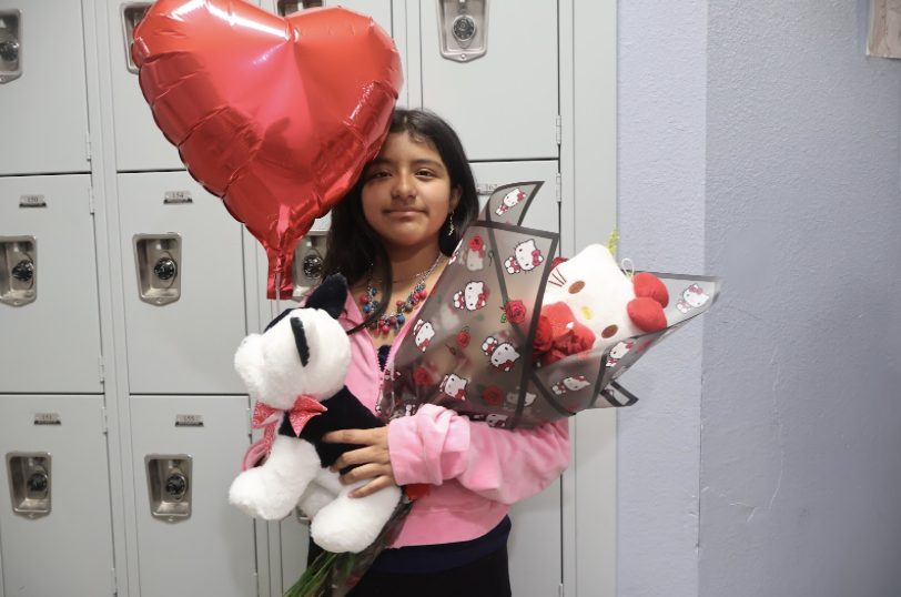 Picture of 6th grade student posing with the gifts she'd received. 
